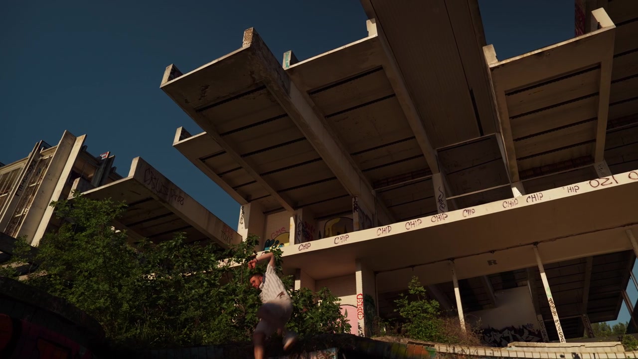 Low angle shot of man standing inside abandoned brutalist hotel complex with graffiti covered concrete architecture and warm evening sunlight in Malinska, Croatia.