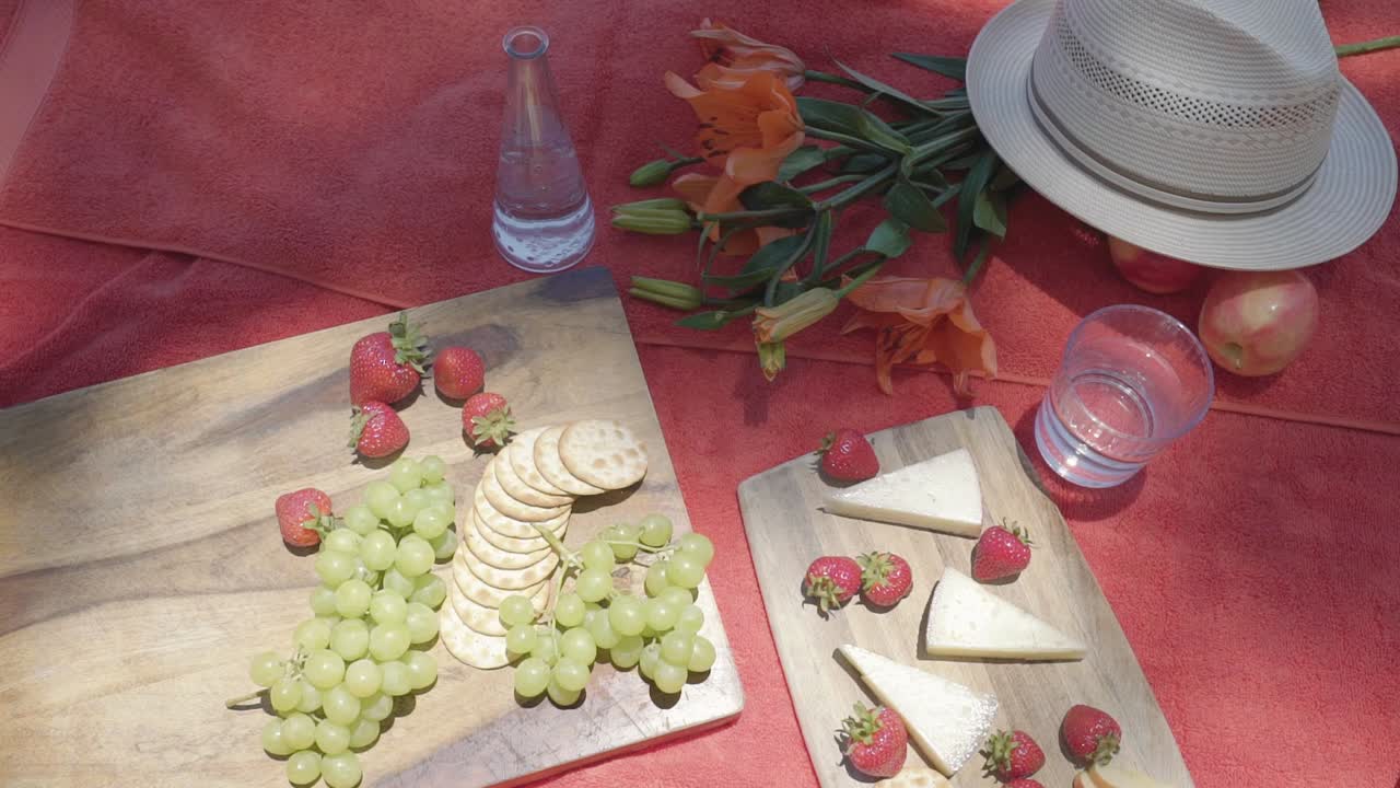 abajo de la parte superior del aperitivo vegetariano queso vegano y fruta fresa uva fruta en mantel rojo concepto de picnic al aire libre