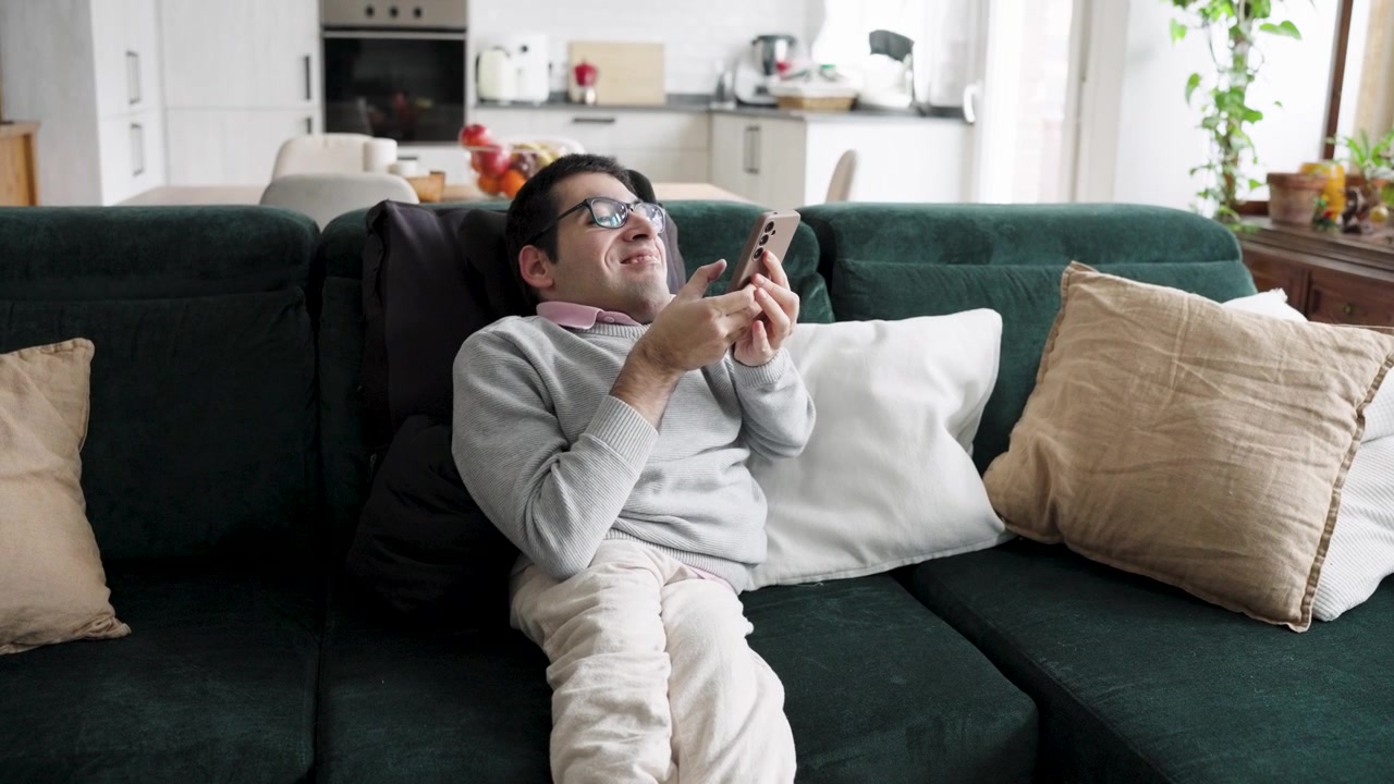 Uomo che si rilassa sul divano e usa lo smartphone a casa