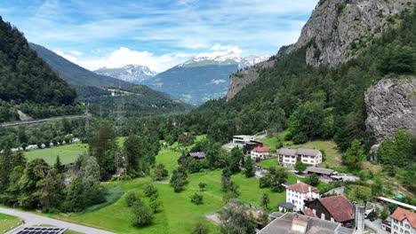 Rothenbrunner,-switzerland-with-lush-greenery,-mountains,-and-scattered-houses,-aerial-view