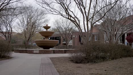 Fountain-with-still-water-on-the-campus-of-Ole-Miss-in-Oxford,-Mississippi-with-video-panning-left-to-right