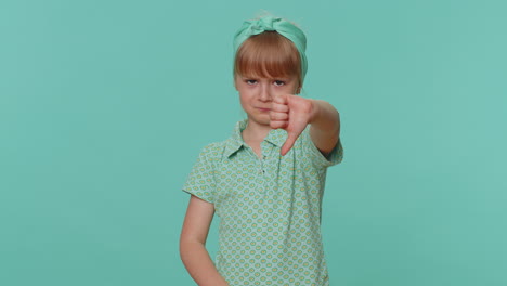 Upset-toddler-children-girl-showing-thumbs-down-sign,-expressing-discontent,-disapproval,-dislike