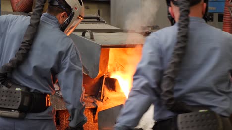 Workers-collaborating-to-melt-metal-at-very-high-temperature