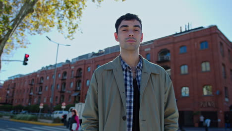 young handsome man standing on the street and posing for camera