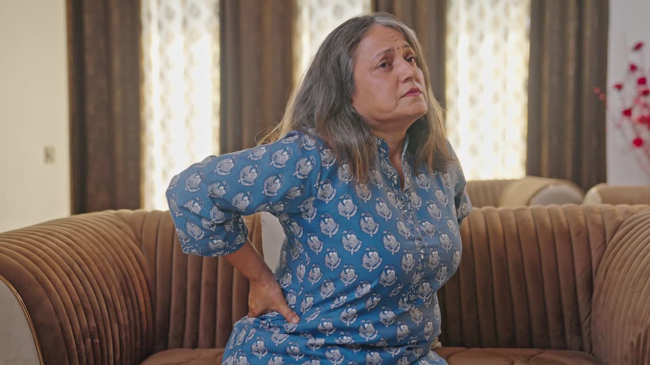 Aged Indian woman suffering from back pain