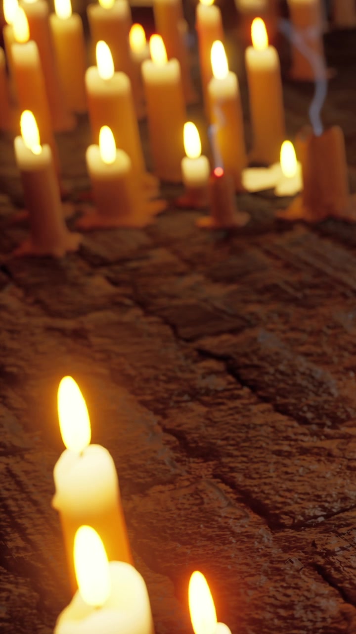 Candele accese su pavimento in legno per un raduno serale.