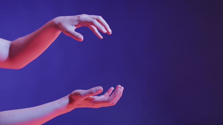 A Caucasian person's hands are captured in a graceful gesture against a blue background, with copy s
