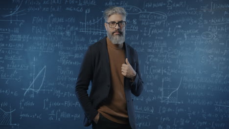Man in front of a chalkboard covered in equations