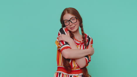 una adolescente pelirroja extiende las manos y da un abrazo, expresión agradable, sentimientos de amor, fondo azul