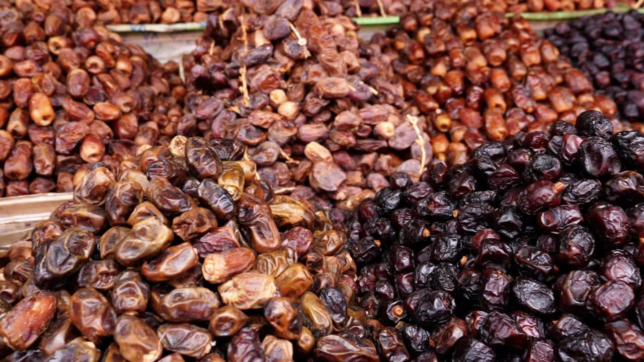 Variety of fresh Moroccan dates, shop display in the Medina of Marrakech (Marrakesh), Morocco. Healthy food snacks, high in vitamins and protein. 4k food background footage.