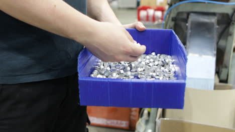 Industrial-factory-worker-checking-metal-pieces-made-by-automated-machine