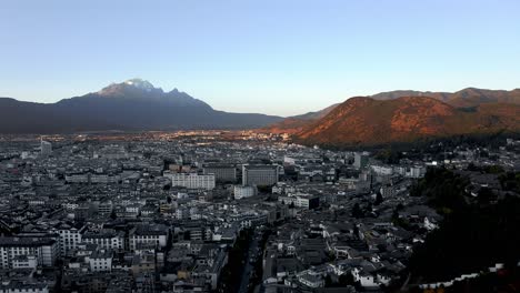 lijiang city and jade dragon mountain, china, aerial sunset landscape