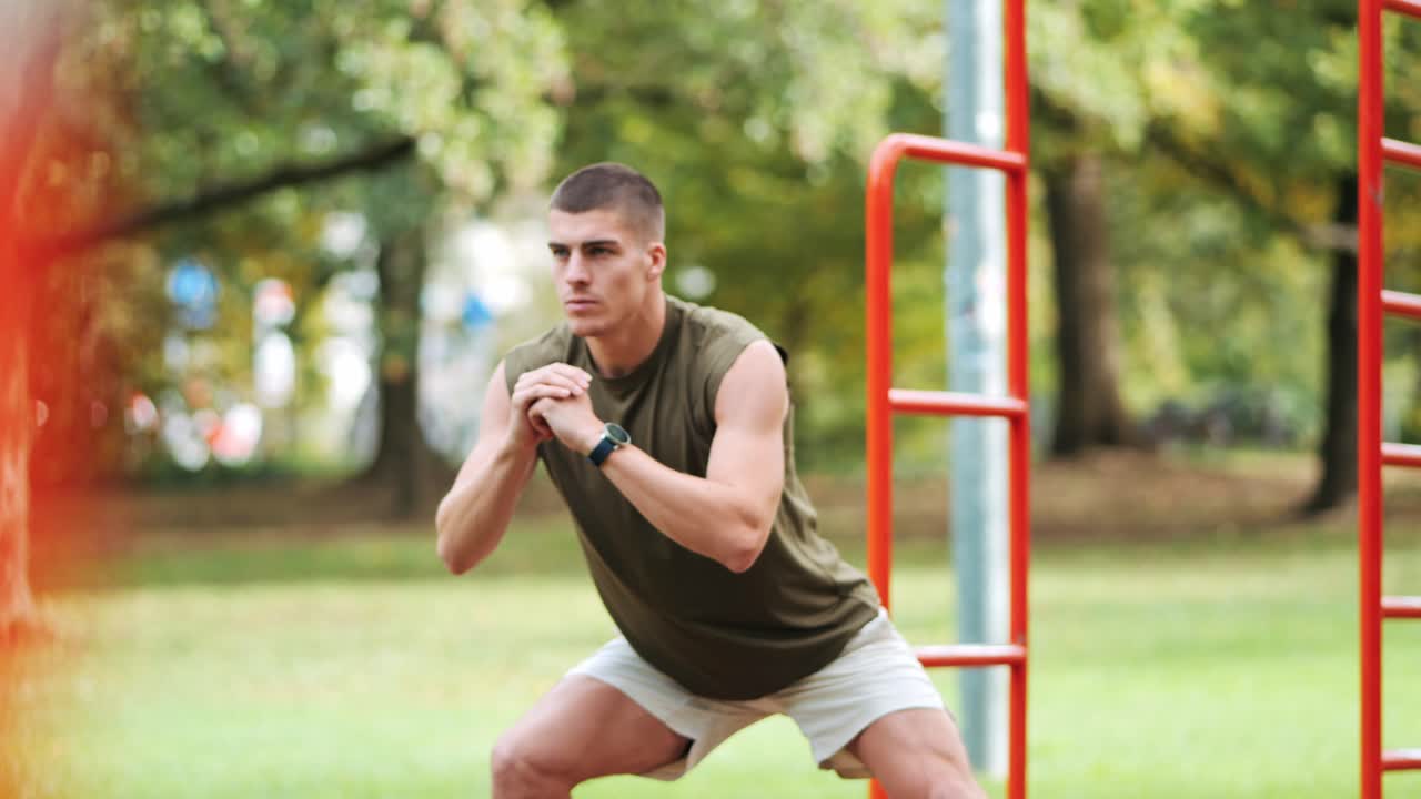 atleta masculino enfocado estira sus músculos en una instalación deportiva al aire libre de un parque