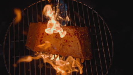 cooking trout red fish with bright burning fire on brazier