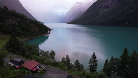 flyover houses by the serene lake of lovatnet and mountain scenery