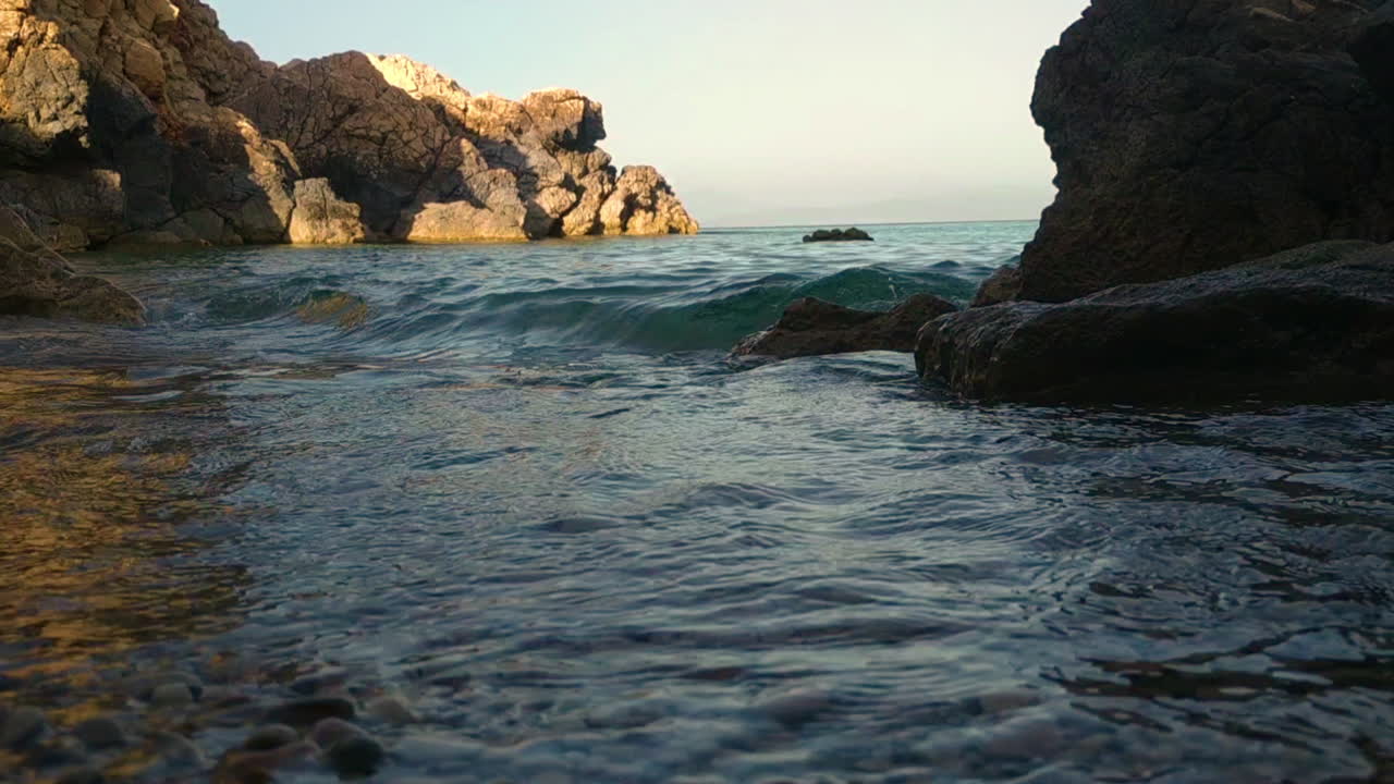 cerca de la corriente de las olas contra la costa rocosa en un día soleado en cerdeña, italia, vacaciones de verano