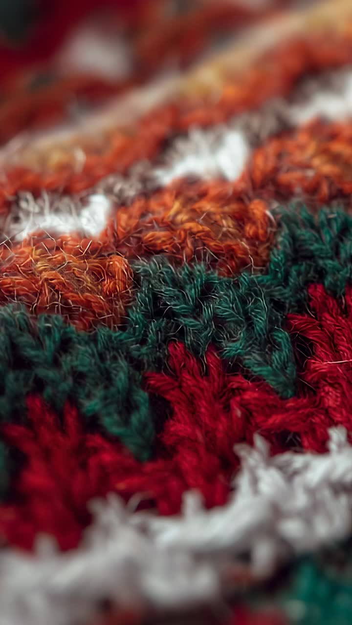 Vertical video: Lens shifting focus across multicolored yarn then revealing knitted loops at home