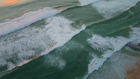sunset flyover with beautiful waves of the indian ocean washing the beach dreamland, bali