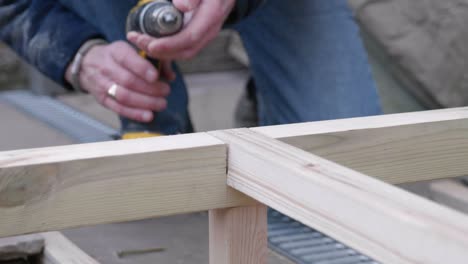 a man swaps drill bits and countersinks some wood