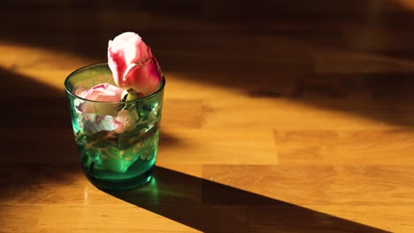 Ein-Glas-Wasser-Mit-Einer-Rosenblüte-Im-Zeitraffer