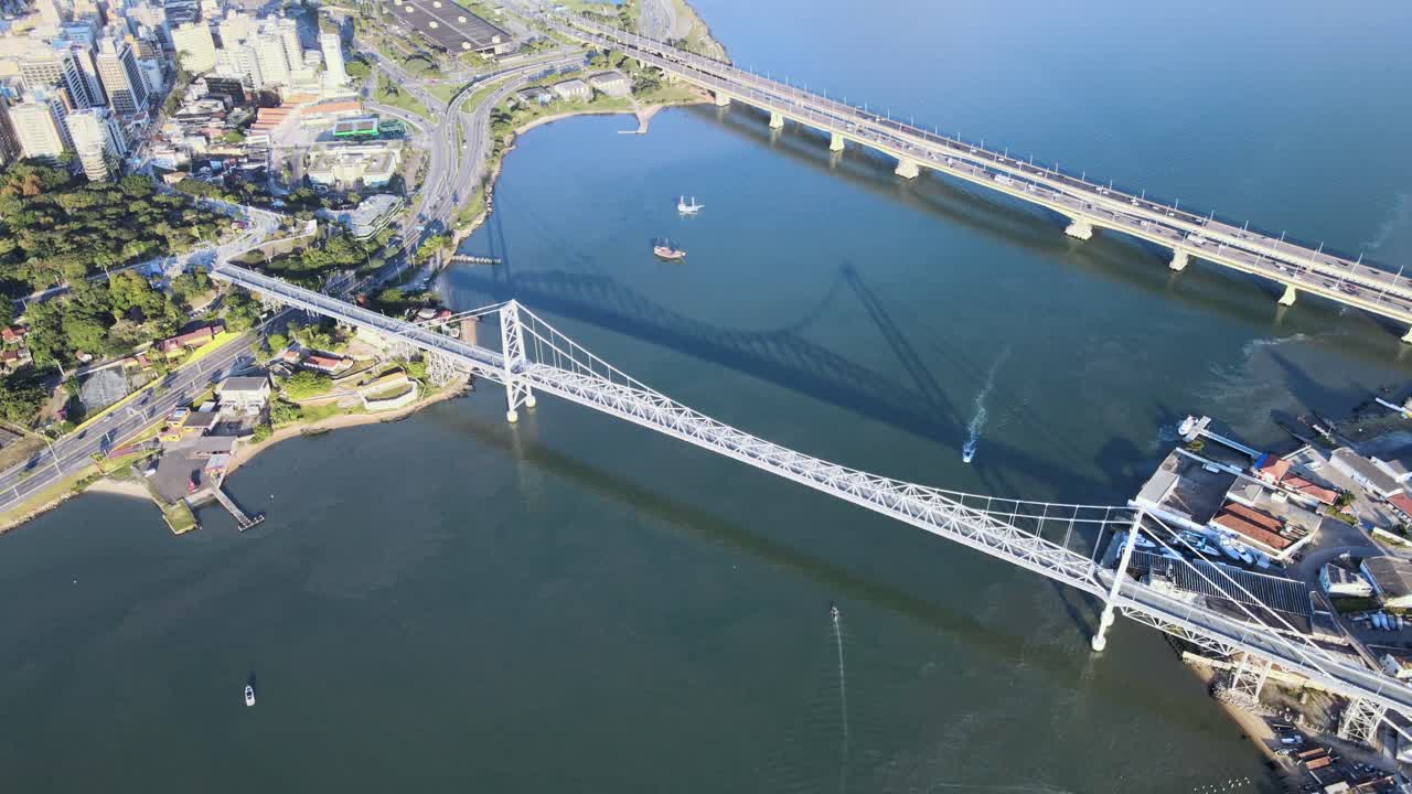 산타 카타리나의 수도인 플로리아노폴리스에 있는 헤르실리오 루즈 페드로 이보 캄포스와 콜롬보 살레스 다리의 드론 공중 장면, 강렬한 차량 통행, 도시화와 바다가 있는 높은 고도의 장면