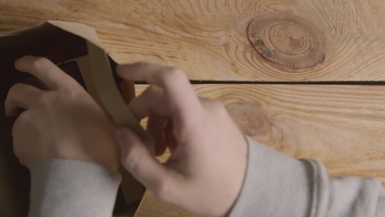 fotografía cenital de un hombre que toma un romántico regalo de san valentín de perfume y una caja de regalo de una bolsa