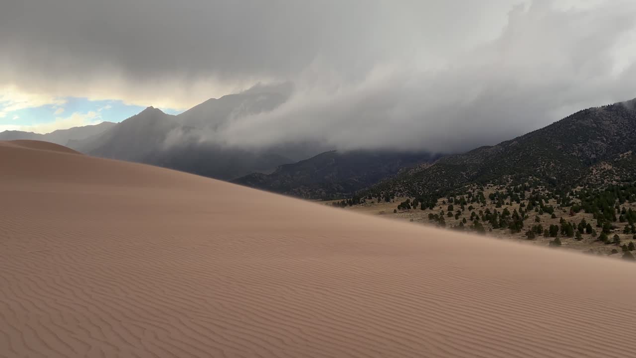 Windy Great Sand Dunes National Park Spring summer stormy foggy cloudy raining mist Crestone Needle peak Colorado Sangre de Cristo range Rocky Mountains magical large amounts of sand dune hills zoom