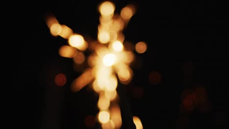 Out-of-focus-party-sparkler-sparkling-on-black-background