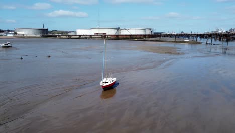 small red fishing boat aerial view of stranded vessel on muddy low tide on liverpool coastline