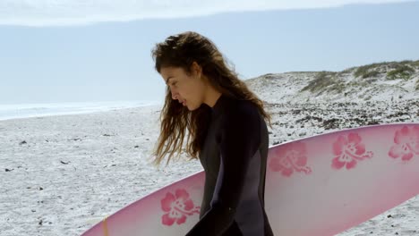 woman walking on the beach with surfboard 4k