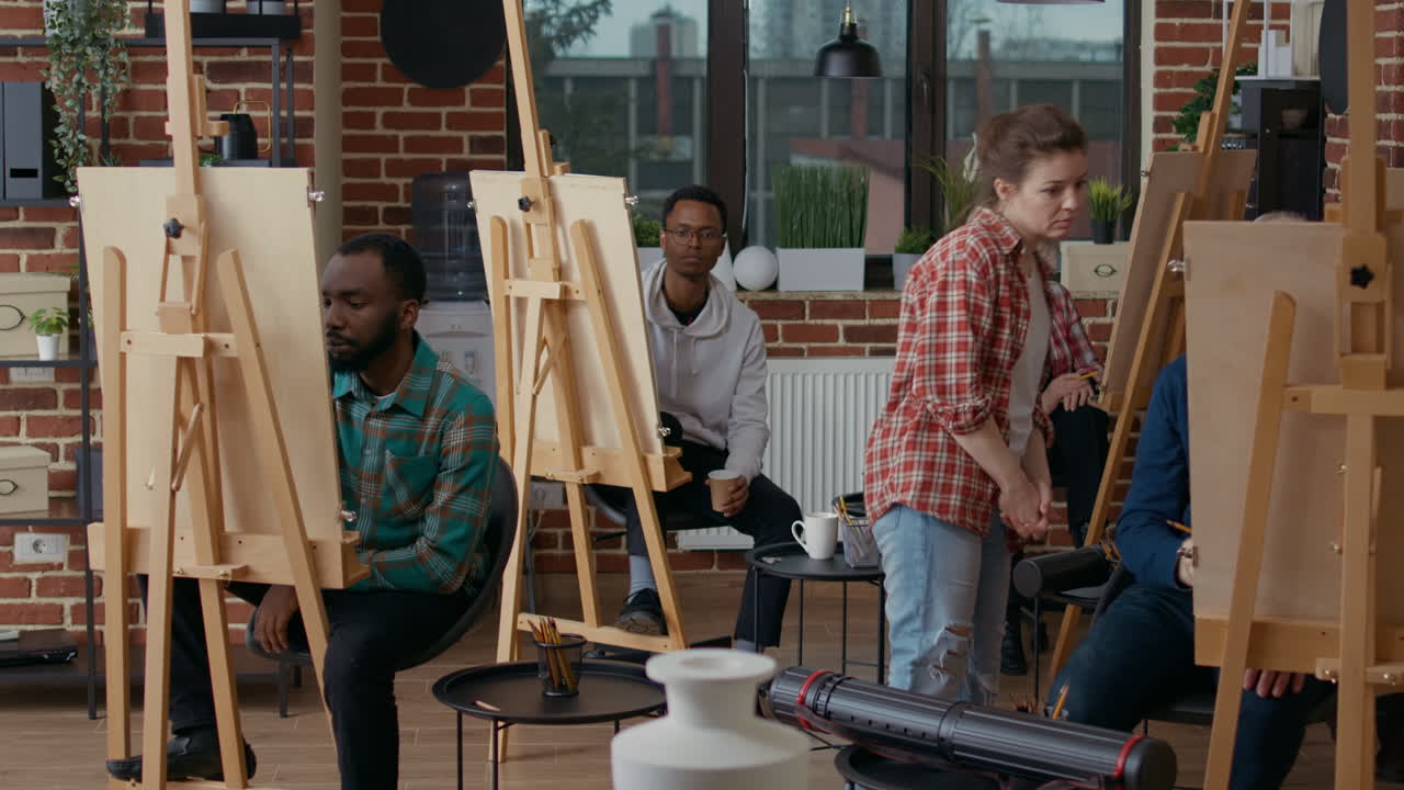 Creative students drawing on canvas in art class workshop