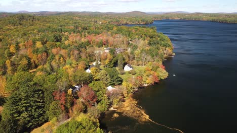 Día-Soleado-De-Otoño-En-La-Orilla-Del-Lago,-Bosque-Denso-Y-Colorido,-Casas-De-Fin-De-Semana,-Lago-Tranquilo