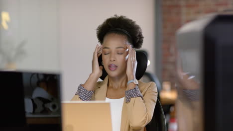 a young african american woman looks stressed at her business office desk