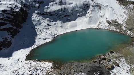 Emerald-lagoon-on-snowy-mountain-slope,-Charquini-in-Bolivian-Andes