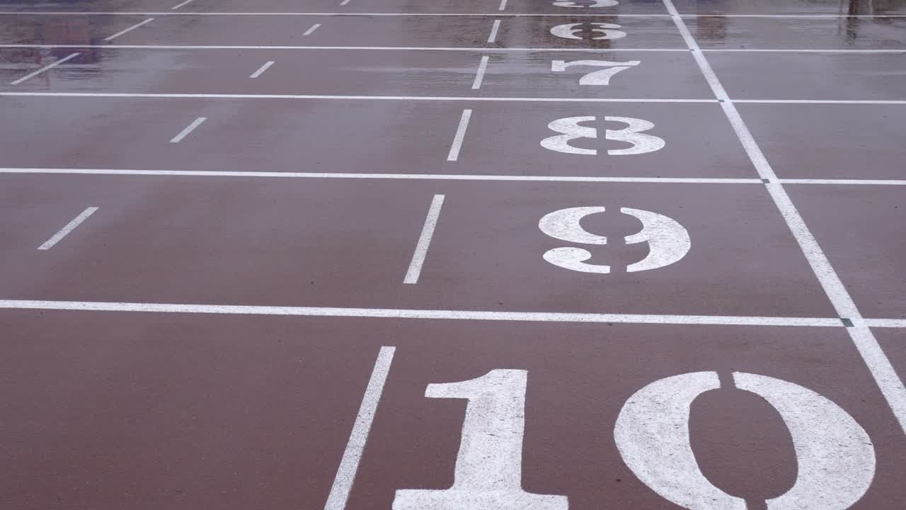 Giorno di pioggia, pista di atletica nello stadio. Il terreno è segnato con le corsie dalla 6 alla 10.