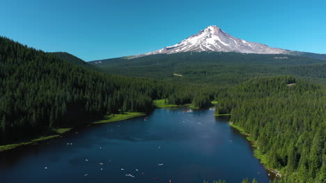 flying over the trillium lake with snowy mount hood background, sunny oregon, usa - aerial view