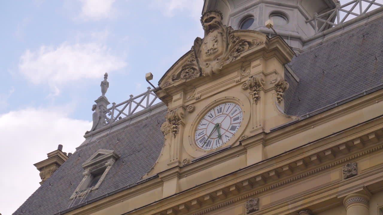 A view of the clock on the Hôtel de Ville in Asnières-sur-Seine, featuring its intricate details and set against a beautiful sky. The clock is part of the historic 19th-century building