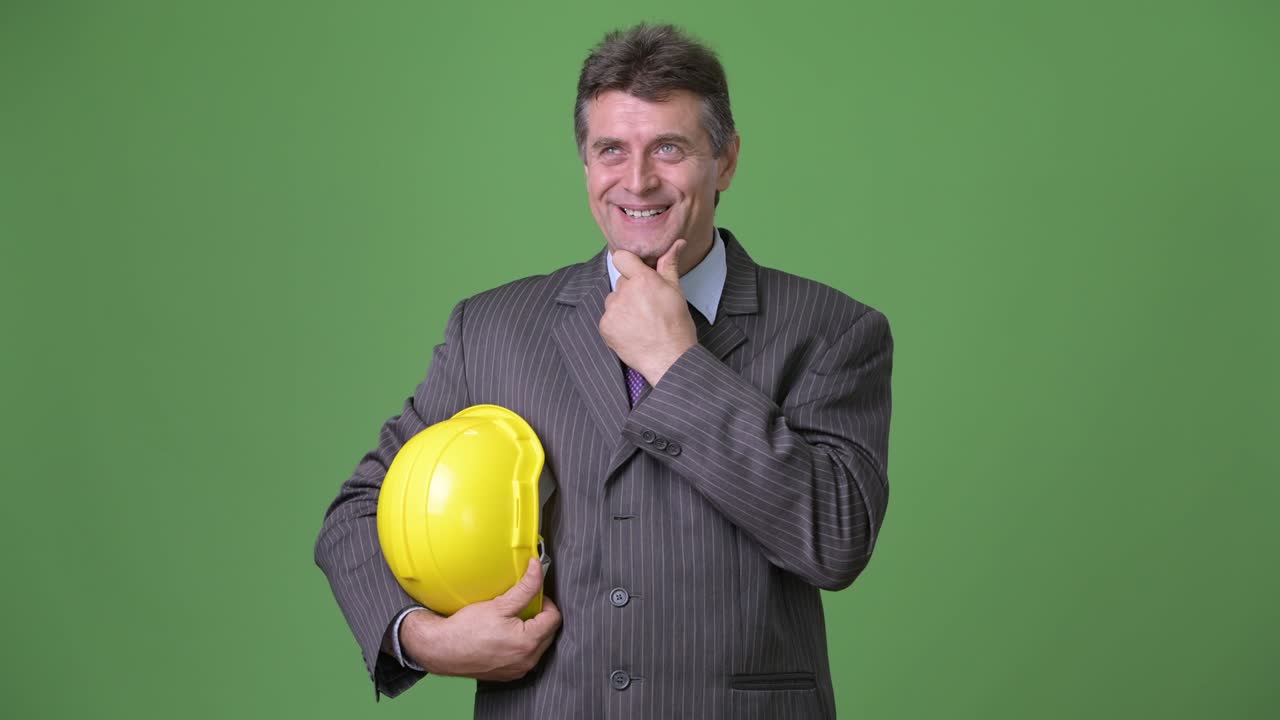 hombre de negocios maduro y guapo contra un fondo verde