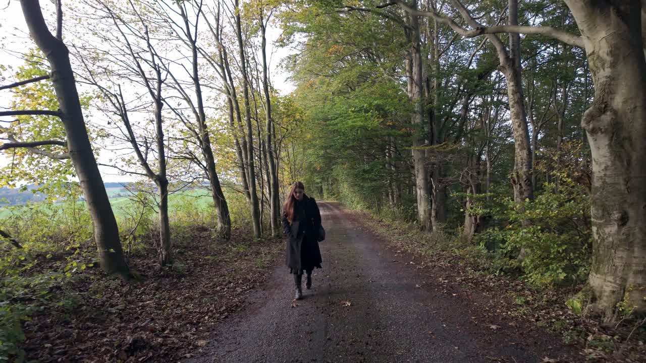 Woman walking on a path in the woods during autumn
