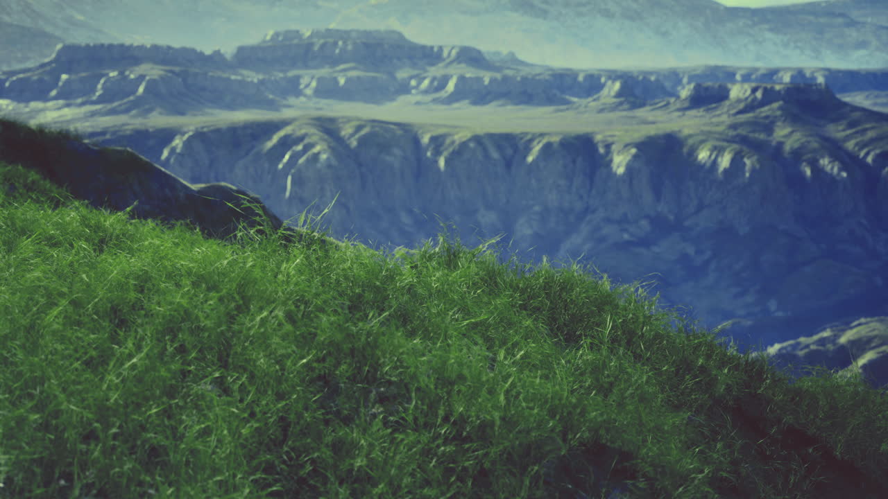 Vast green hills overlook rugged cliffs under a serene blue sky