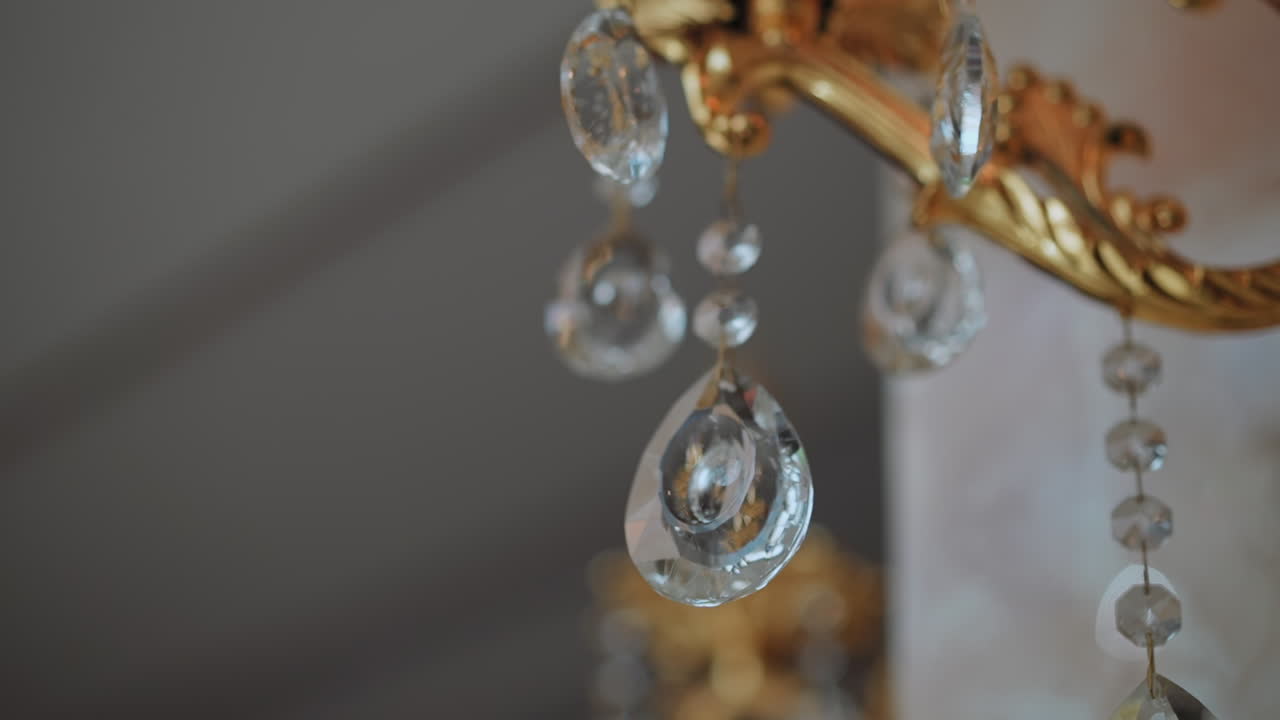 눈물 모양의 크리스탈 장식은 빈티지 황금 빛에 매달려 있습니다.