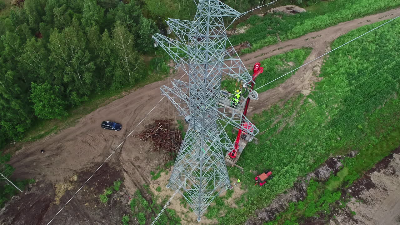 Electricity Workers On Steel Pylon Transmission Tower In Daytime