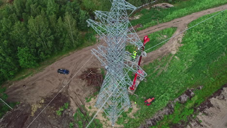 electricity workers on steel pylon transmission tower in daytime