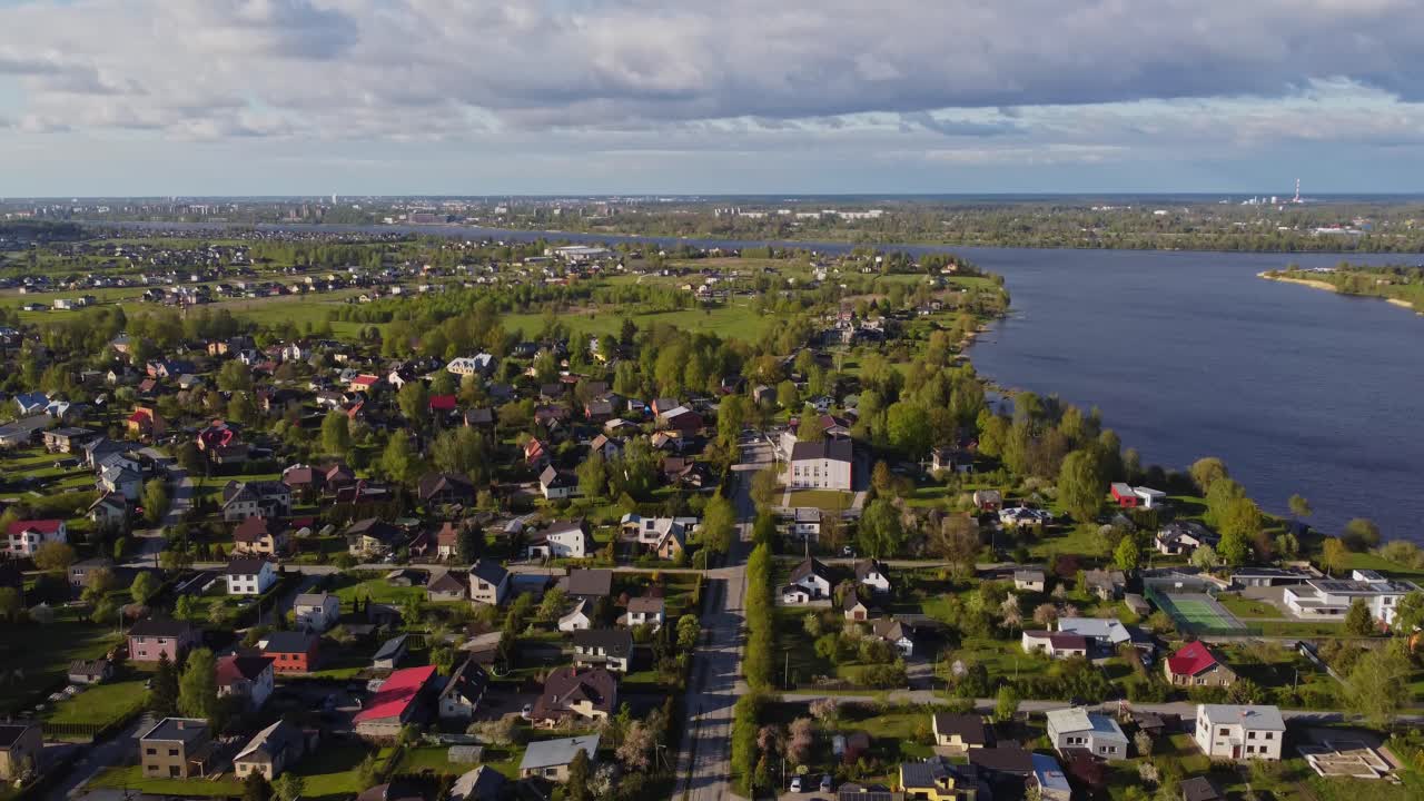 Aerial view moving backward over Katlakalns neighborhood in springtime serenity