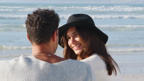 rear view of romantic couple on winter beach vacation