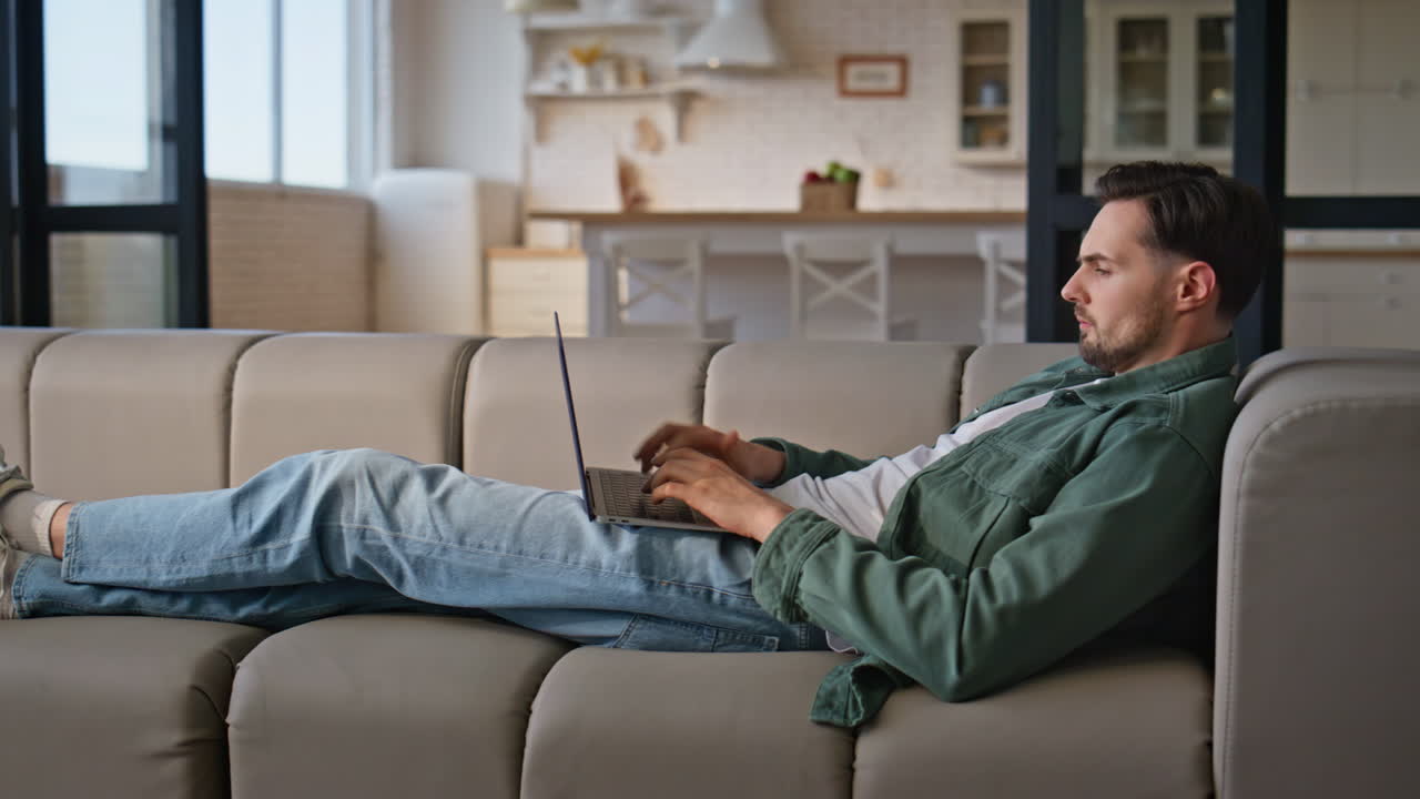 Lying businessman working laptop computer at remote office. Freelancer surf web