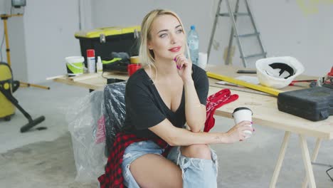 trendy female sitting at carpenter workbench