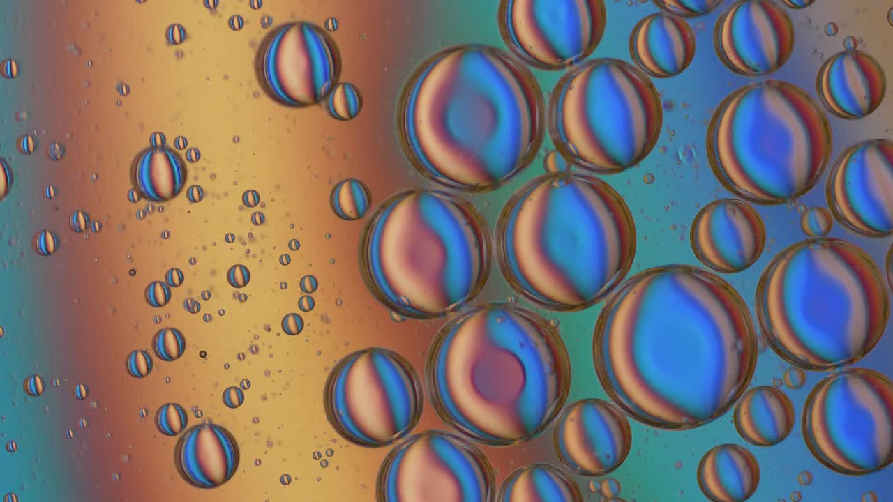 Close up shot of multicolored oil bubbles rotating in liquid. Abstract wallpaper concept.