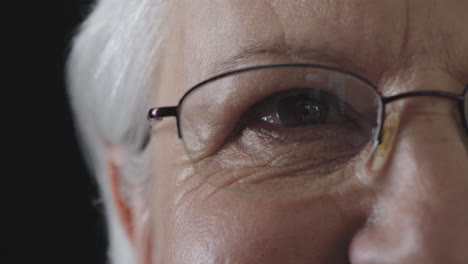 close-up-of-elderly-woman-eye-looking-at-camera-blinking-wearing-glasses