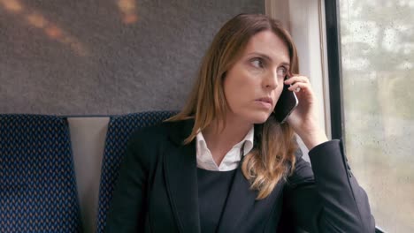 Businesswoman-using-phone-on-the-train